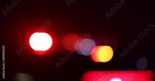 Abstracted illuminated night view of police units on a city street.