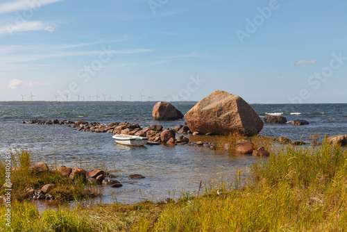 TALLINN, ESTONIA - AUGUST, 15, 2024: Rocky sea coast with large boulders and shallow water under a clear sky.