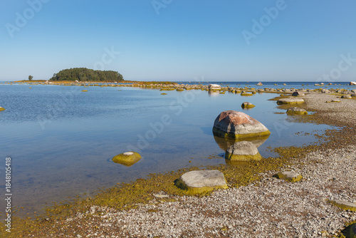 Single large rock near shoreline in shallow coastal water