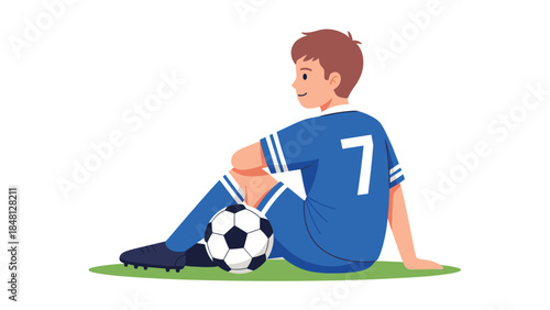Young soccer player sits on the grass with a ball, looking thoughtfully to the side during a break in the game.