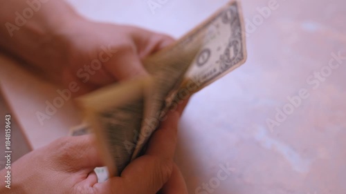 Male hands quickly counting a stack of one-dollar bills, representing concepts of income, payment, personal finance management, and the value of cash in the american economy