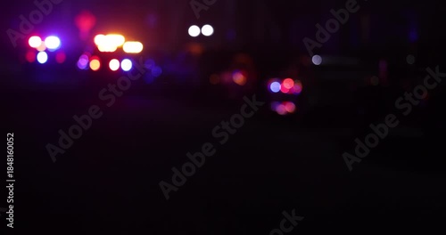 Abstracted illuminated night view of police units on a city street.