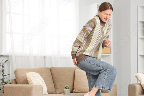 Photos Young woman with hemorrhoids and cactus on sofa at home