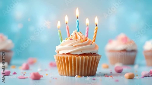 Birthday Cupcake with Lit Candles on Light Blue Background, Slow Motion