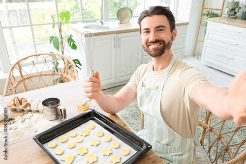 Young man with raw cookies ...