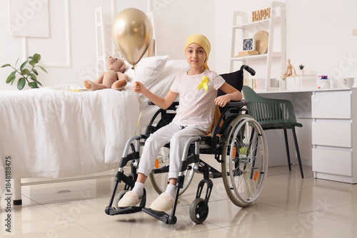 Little girl after chemotherapy with yellow ribbon and balloon in wheelchair a...