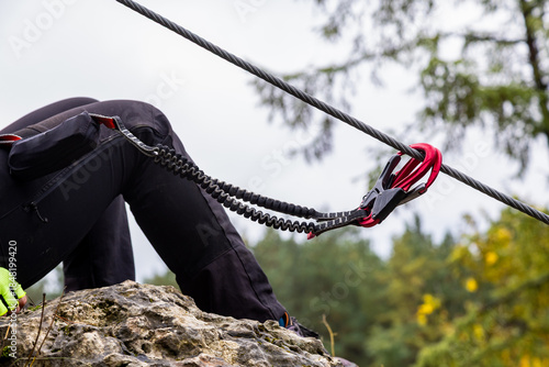 Fototapeta Naklejka Na Ścianę i Meble -  Close-up. Via ferrata. An unidentified person climbs in the mountains  with the help of fixed safety ropes. Krakow-Czestochowa Upland, Poland
