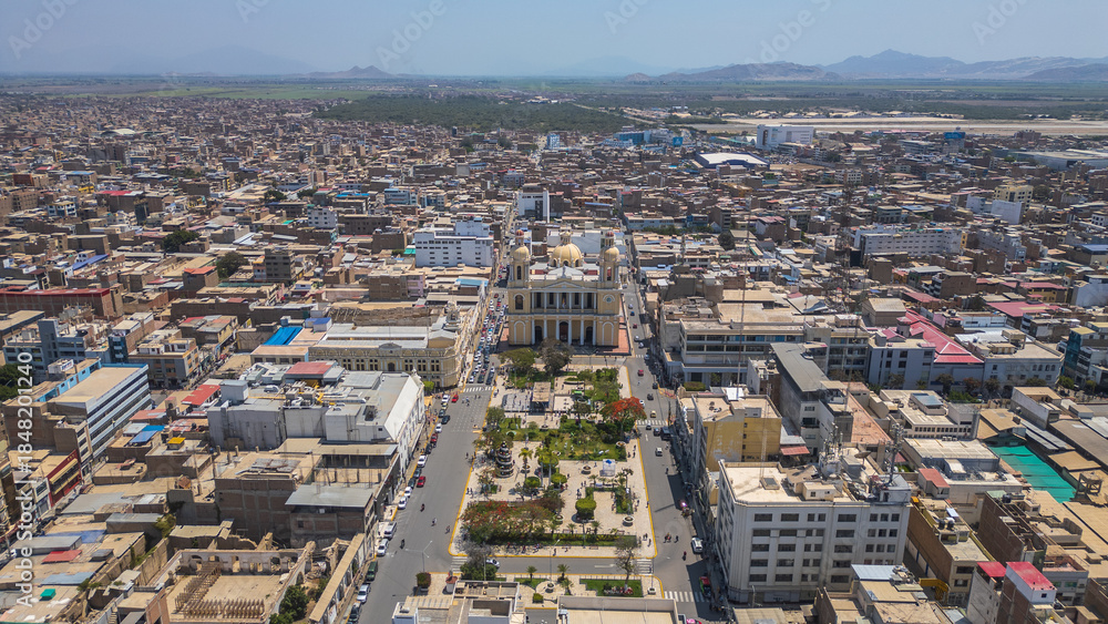 Fototapeta premium Chiclayo’s Main Square featuring the iconic Cathedral, central fountain, green gardens, and a lively urban atmosphere that reflects the cultural and social heart of the city in northern Peru