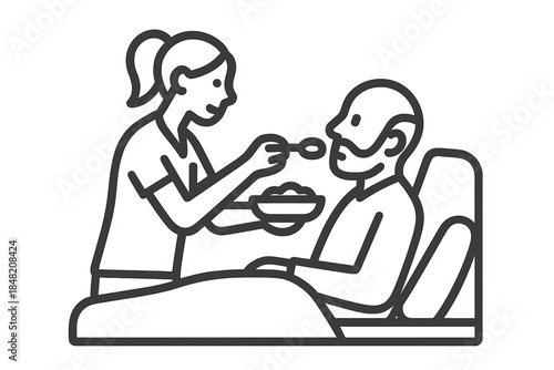Caregiver feeding patient in bed