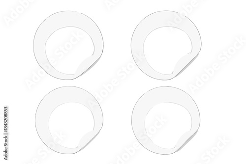 Four blank white circular stickers with lifted edges