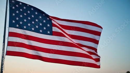 Waving national flag with stars and stripes against a clear sky