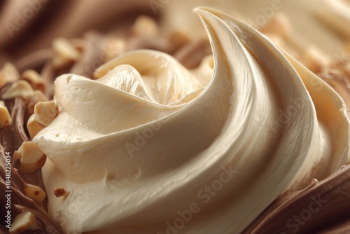 A close-up of creamy dessert swirls with chocolate and chopped nuts, illuminated by soft natural lighting.
