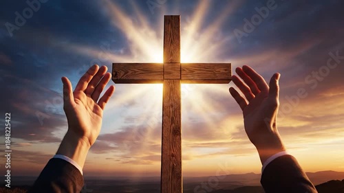 Wooden cross with bright light and human hands reaching out to sky during sunset worship