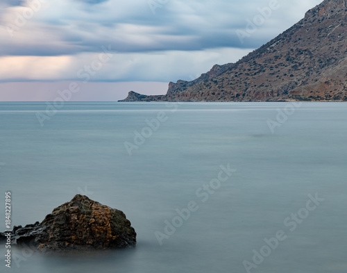 Minimal seascape with calm water and rocky headland