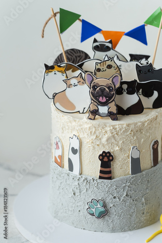 Beautiful big birthday cake decorated with edible dogs and cats figurines on the white background. Cake for a little dog and cat lover