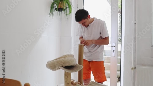 One man is repairing a cat house with pliers.