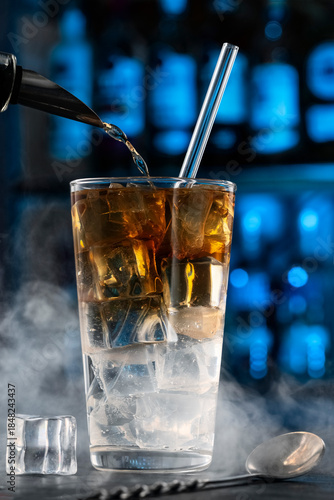 whiskey highball. Bartender Pouring Alcohol into Iced Glass – Cocktail Preparation in Bar