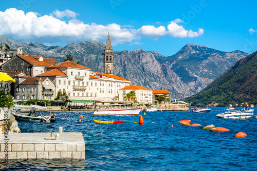 View of the historic town of Perast at famous Bay of Kotor on a beautiful sunny day with blue sky and clouds in summer, Montenegro. 