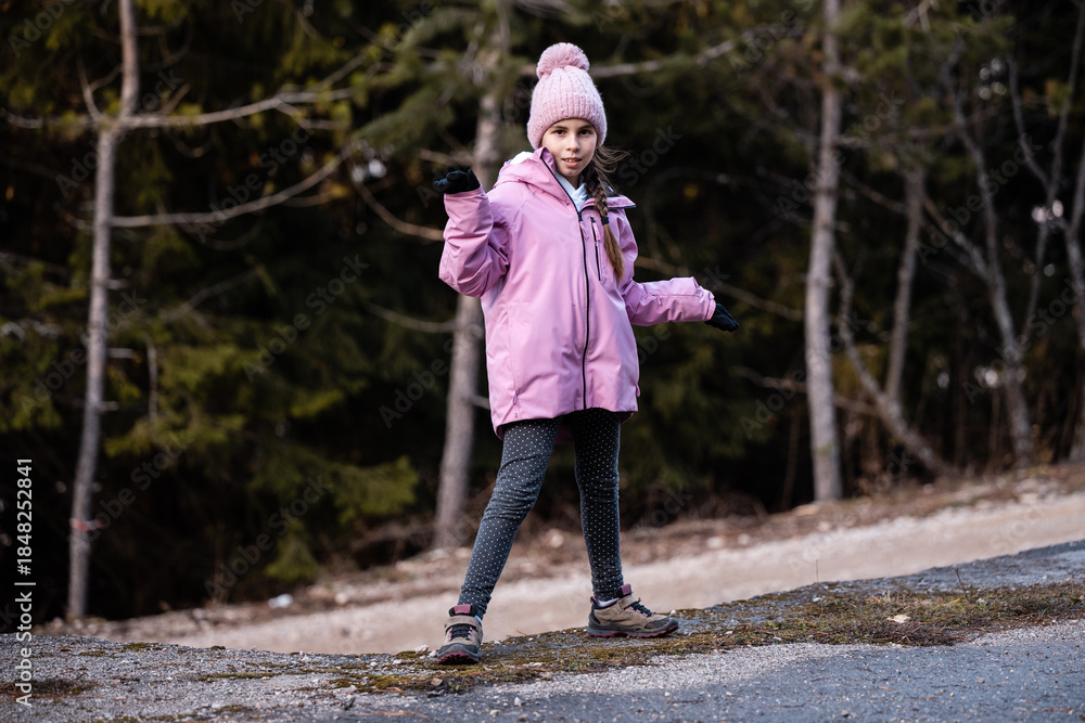 Fototapeta premium Young girl posing outdoors wearing pink winter jacket