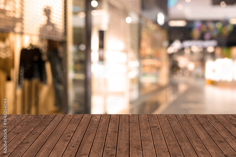 Fototapeta premium Empty wooden table against blurred view of shopping mall. Space for design