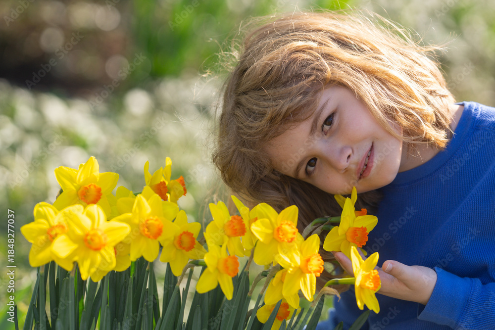 Fototapeta premium Spring fun for kids. Child play outdoors in a beautiful spring garden. Kid face in flowers. Adorable little kid in blooming cherry garden on beautiful spring day. Happy child during spring blossom.