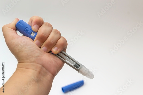 Hand Holding Medical Injection Pen on White Background, isolated, copy space