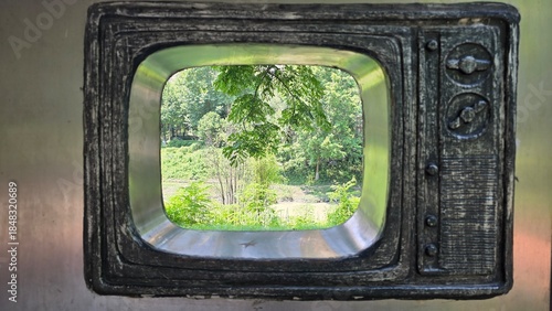 Retro Television Sculpture in Urban Park Surrounded by Green Landscape