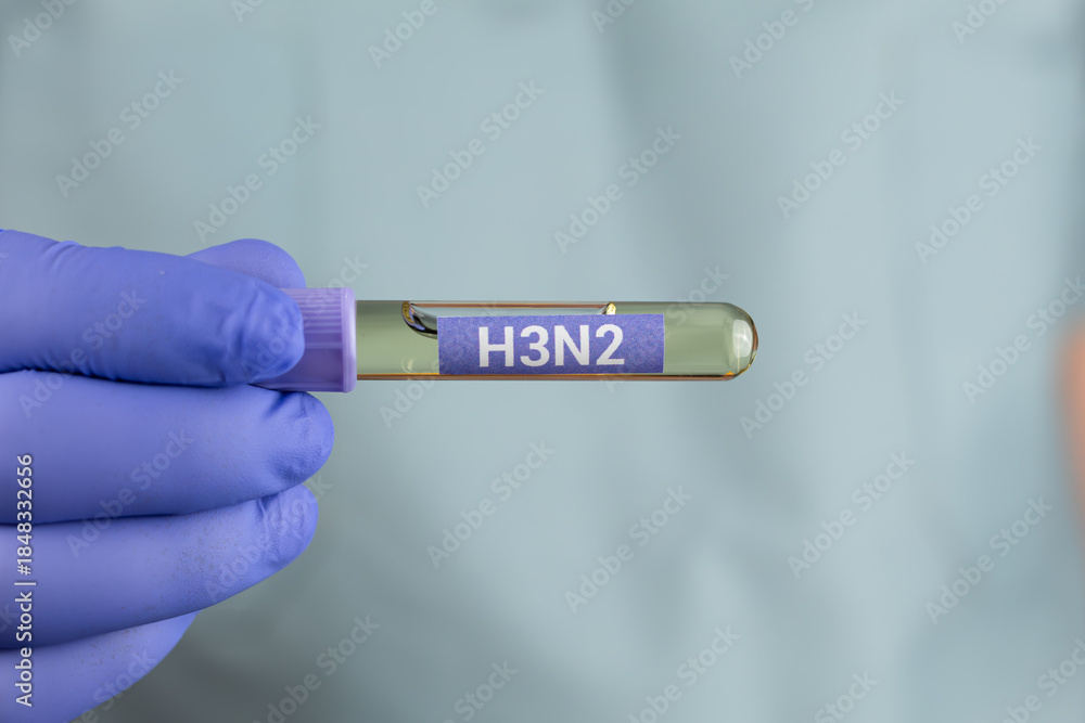 Obraz premium A doctor's hand holding a test tube labeled H3N2. Concept of influenza virus detection, laboratory diagnosis, infectious disease testing, and public health awareness.