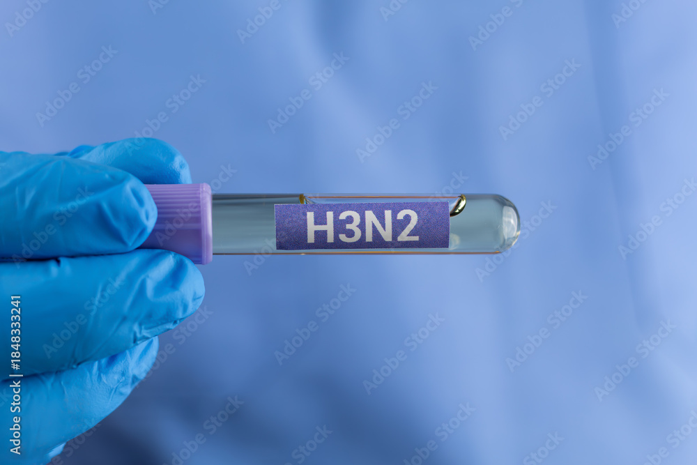Obraz premium A doctor's hand in a blue glove holding a test tube labeled H3N2. Influenza virus detection, laboratory diagnosis, infectious disease testing, and public health concept.