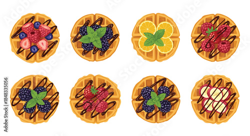 Top-down view of a set of delicious Belgian waffles decorated with various fresh berries, fruit, chocolate sauce, and mint.