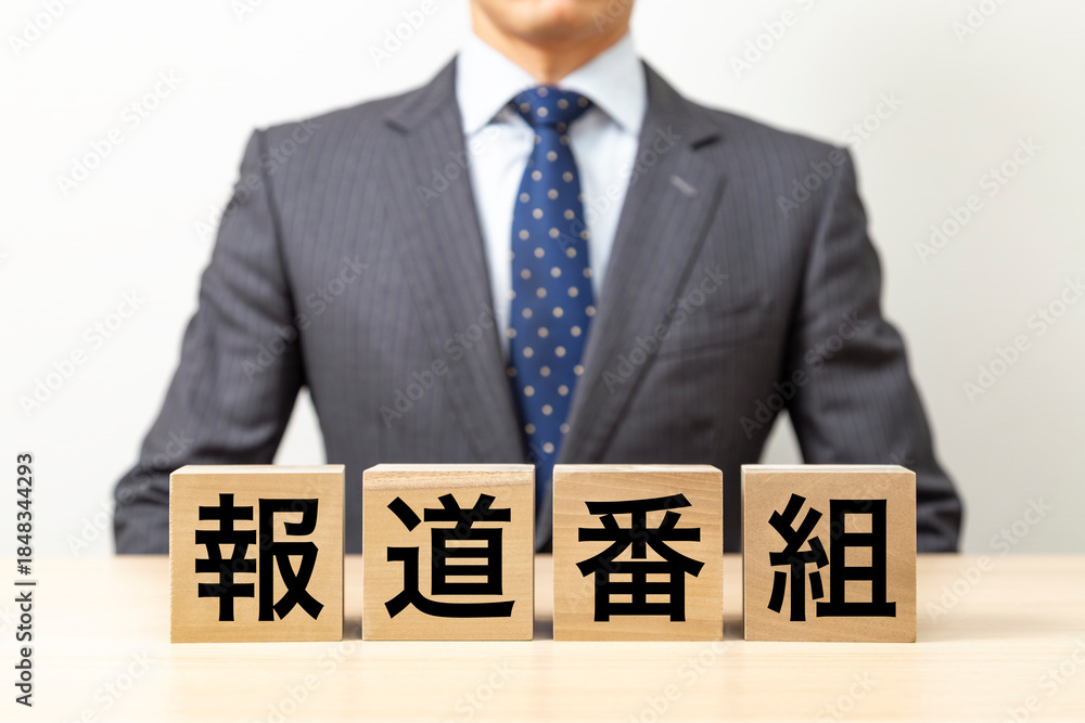 Obraz premium 「報道番組」と書かれたブロックとビジネスマン