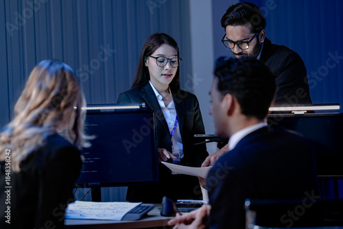 Data integrity check night shift Diverse team meticulously audits financial performance comparing figures tablet screen printed reports ensuring accuracy crucial validation process underway hub.