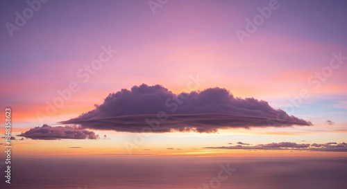 A captivating sunset paints the sky with vibrant hues, as a solitary cloud floats serenely above the tranquil sea, creating a breathtaking scene