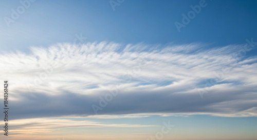 A beautiful blue sky with wispy clouds stretching across the horizon, creating a serene and peaceful atmosphere at sunset