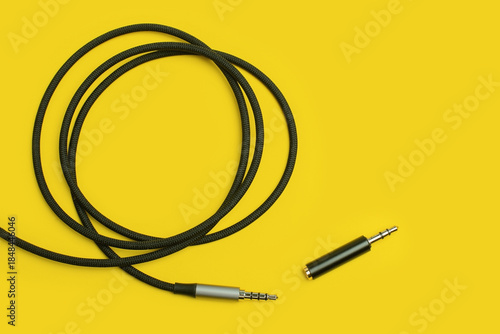 Audio cable with adapter trrs to trs on yellow backdrop