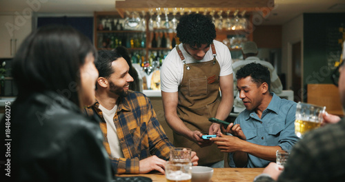 Fotografija Waiter, man and phone with payment at pub for beer purchase, paperless transaction or drinking
