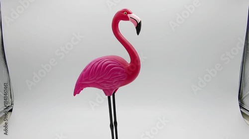 Pink plastic flamingo decoration against a bright white background. Suitable for summerthemed designs, party invitations, and tropical concepts.