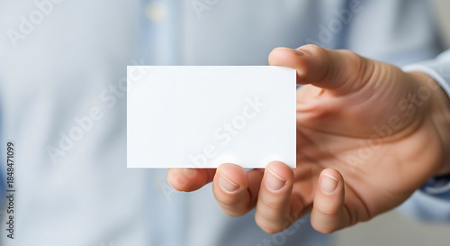 Close-up of a human hand presenting a pristine, empty white card, ideal for a professional business introduction or personalized information display