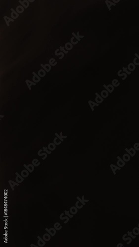 Close up of young woman playing with her hair in the dark with bright light.