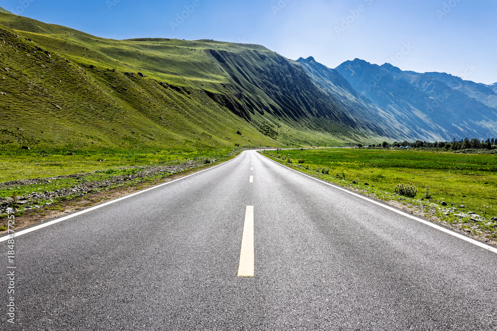 Naklejka premium Empty asphalt road and green mountain natural landscape under blue sky