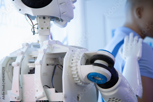 white humanoid robot helps a person at work