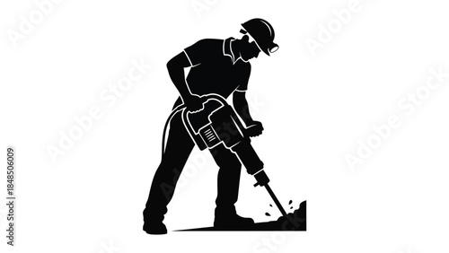 Silhouette of a construction worker operating a jackhammer on the ground