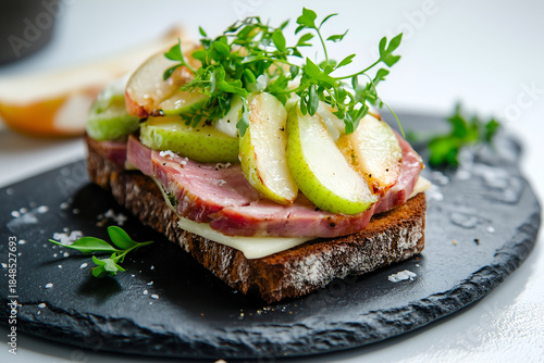 Gourmet Rye Bread Sandwich with Ham, Cheese and Sliced Pear on Dark Slate