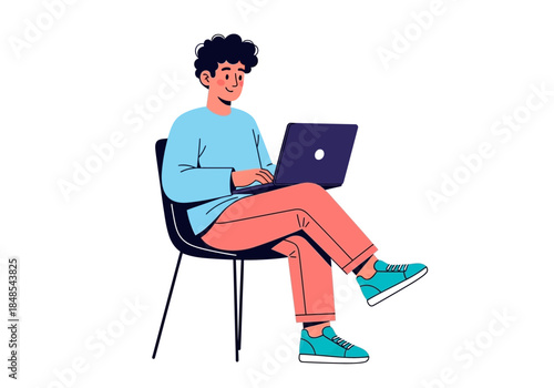 Young man with curly hair sitting on a chair and working on a dark laptop computer