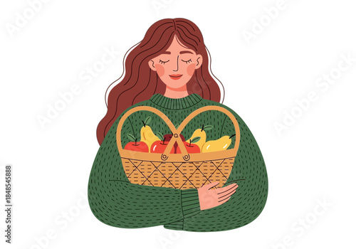 Young woman with long brown hair wearing a green sweater holding a wicker basket full of fresh autumn fruit