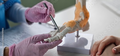 Photos Podiatrist showing anatomical foot skeleton model concept