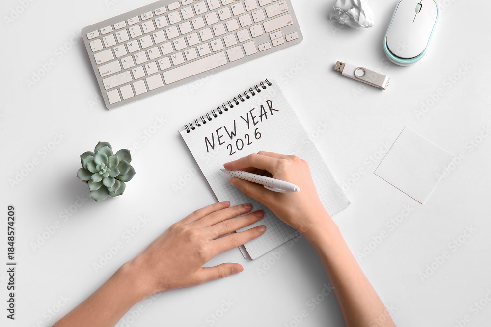 Naklejka premium Woman with keyboard writing new year plans on 2026 against white background