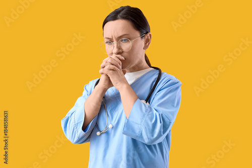 Worried nurse on yellow bac...