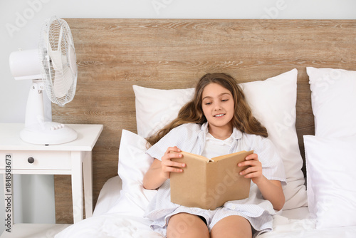 Teenage girl lying on bed w...