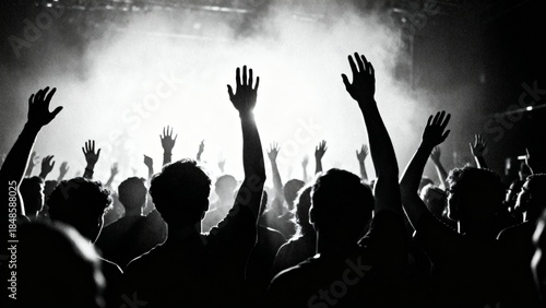 Crowd raising hands at live concert in black and white